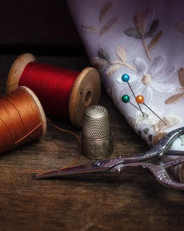 قیچی، نخ و ابزار دوخت روی پارچه گل‌دار