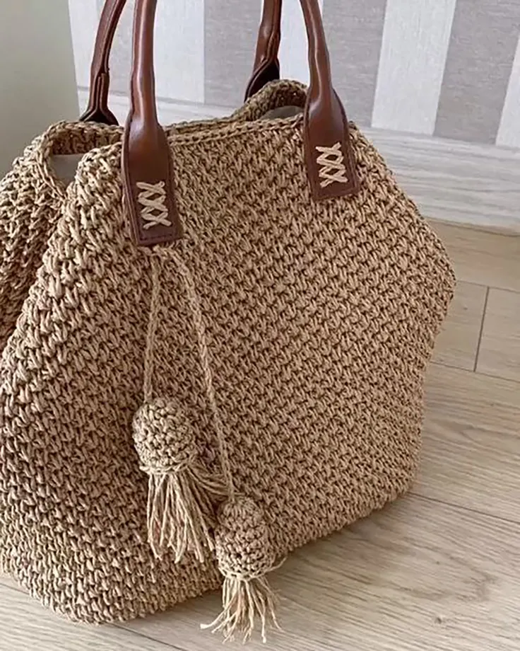 کیف دستی بافت بژ با دسته چرمی و آویز پوم‌پومی
